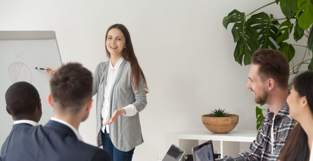 Mujer presentando un plan de como implementar ticket guardería a los compañeros de trabajo