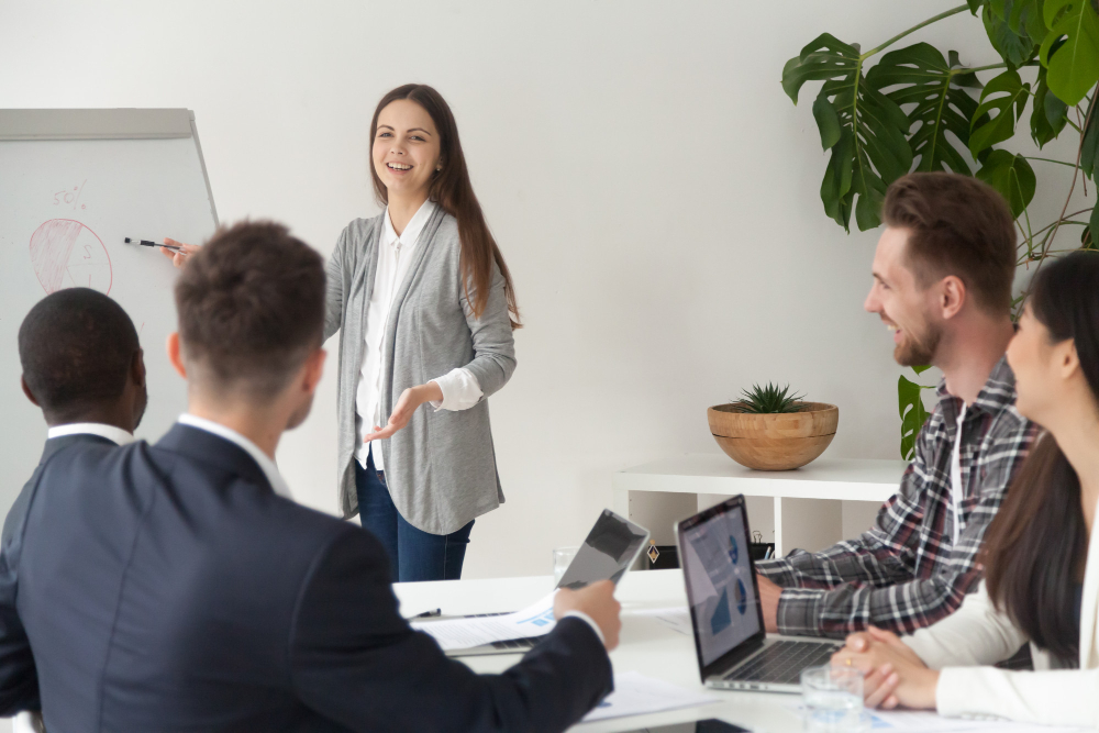 Mujer presentando un plan de como implementar ticket guardería a los compañeros de trabajo