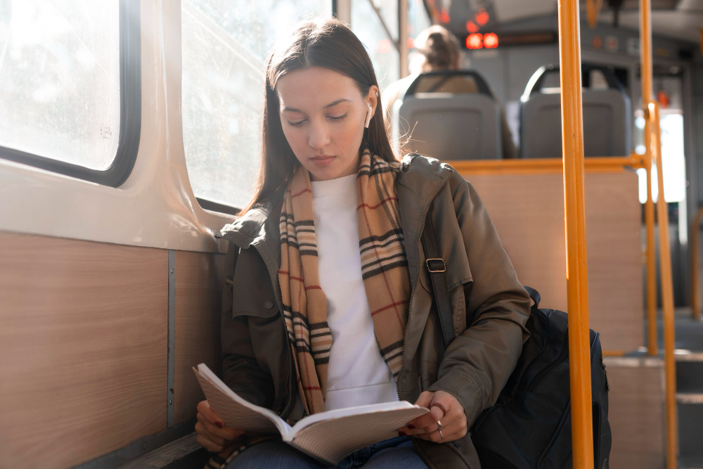 Chica leyendo en el transporte público de camino hacia su trabajo