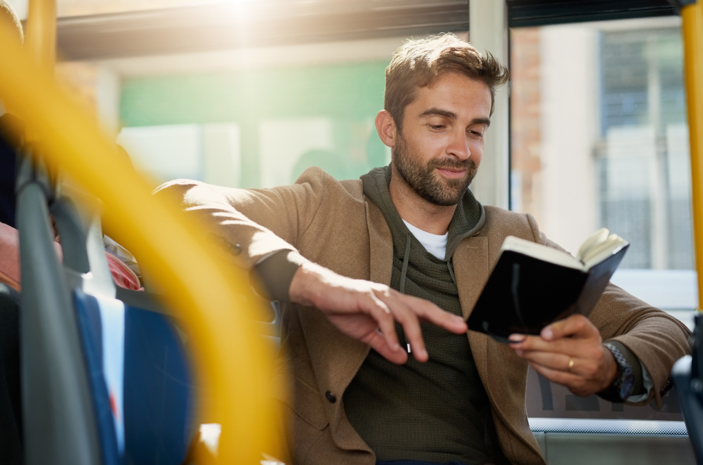 chico leyendo un libro sentado en el autobús