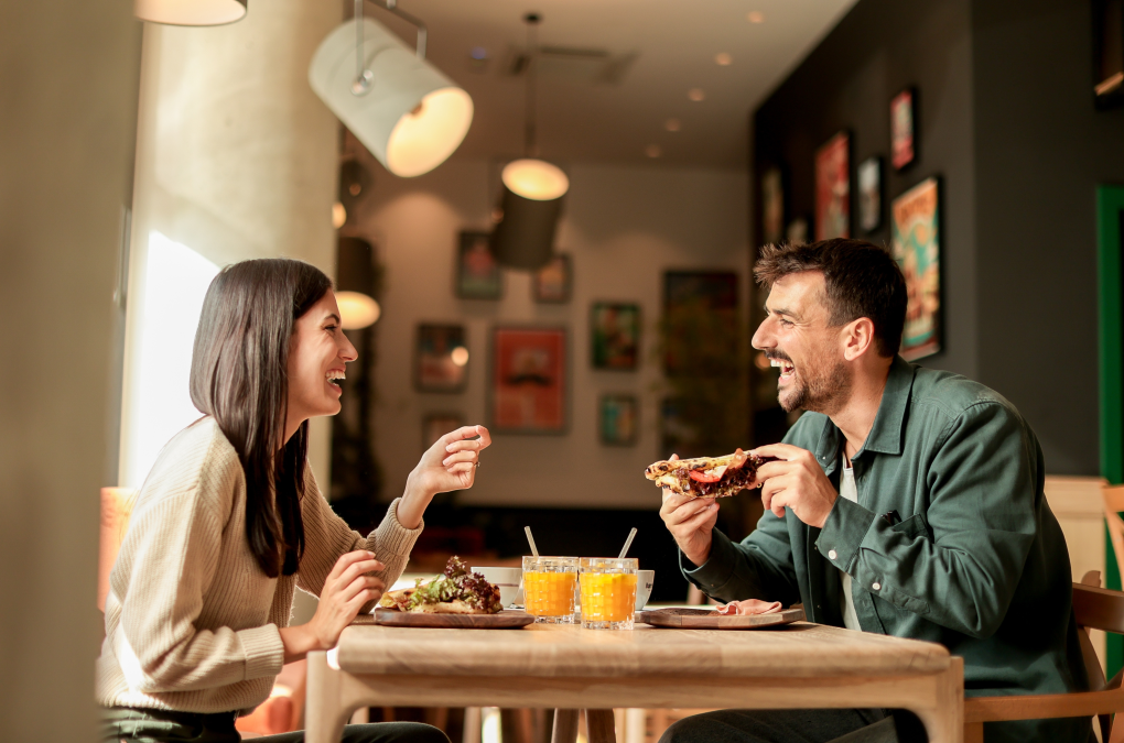 una chica y un chico comiendo contentos en un restaurante