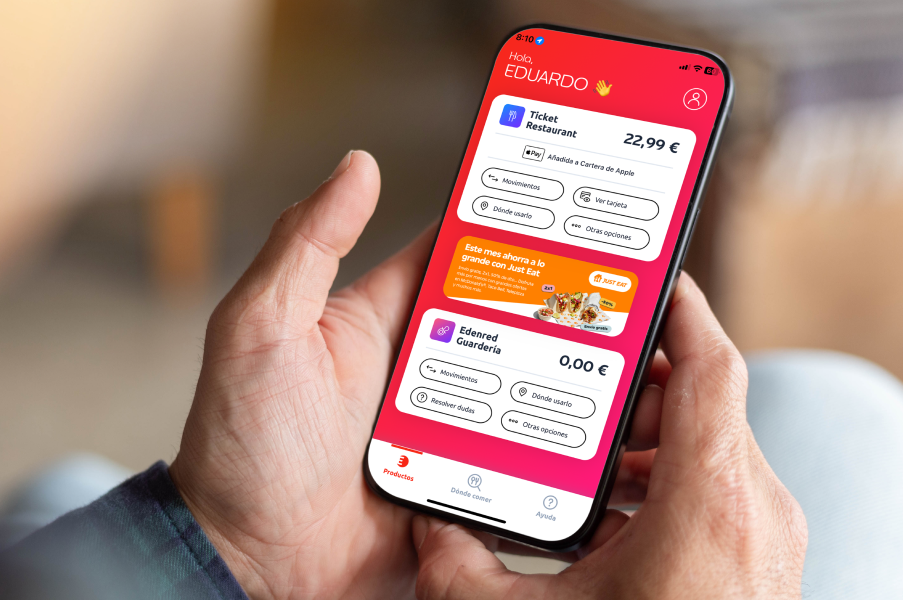 Mano sosteniendo smartphone con la aplicación de Edenred mostrando saldo y beneficios