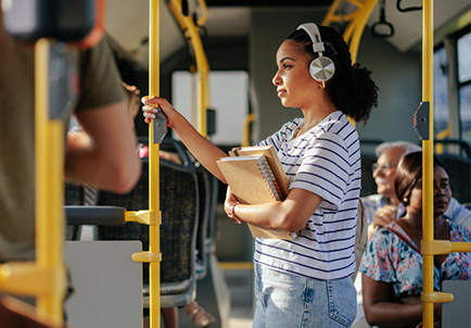 Mujer con auriculares escuchando música en autobús urbano