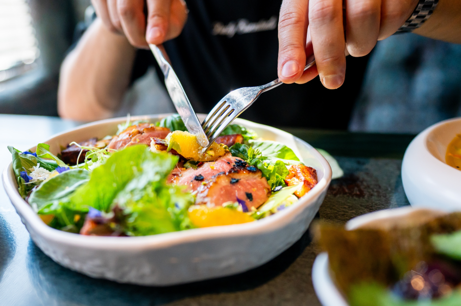 Persona disfrutando ensalada fresca y saludable en restaurante