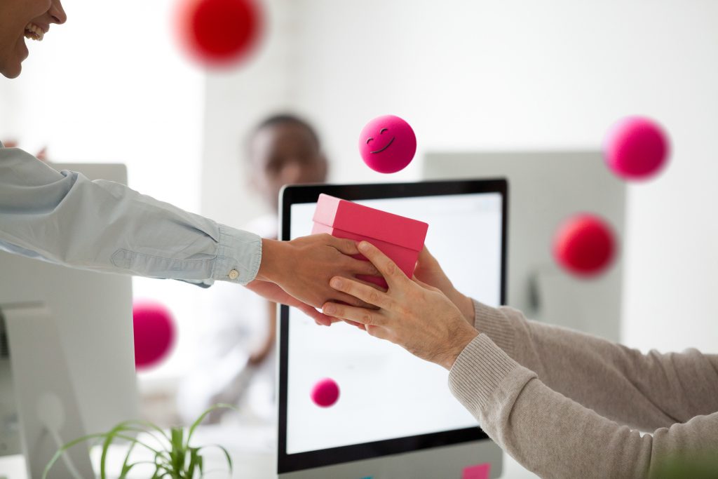 Mano sosteniendo tarjeta de pago frente a ordenador para compra online