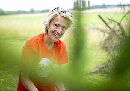 Mujer sonriente disfrutando de la naturaleza en campo verde al aire libre