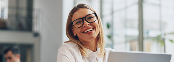 Woman with glasses smiling in modern office