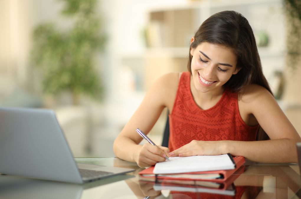una chica joven escribiendo sus propósitos en una libreta