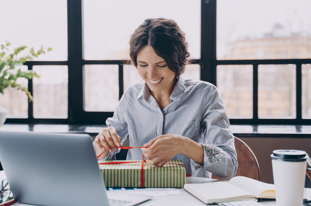 una mujer contenta abriendo un regalo