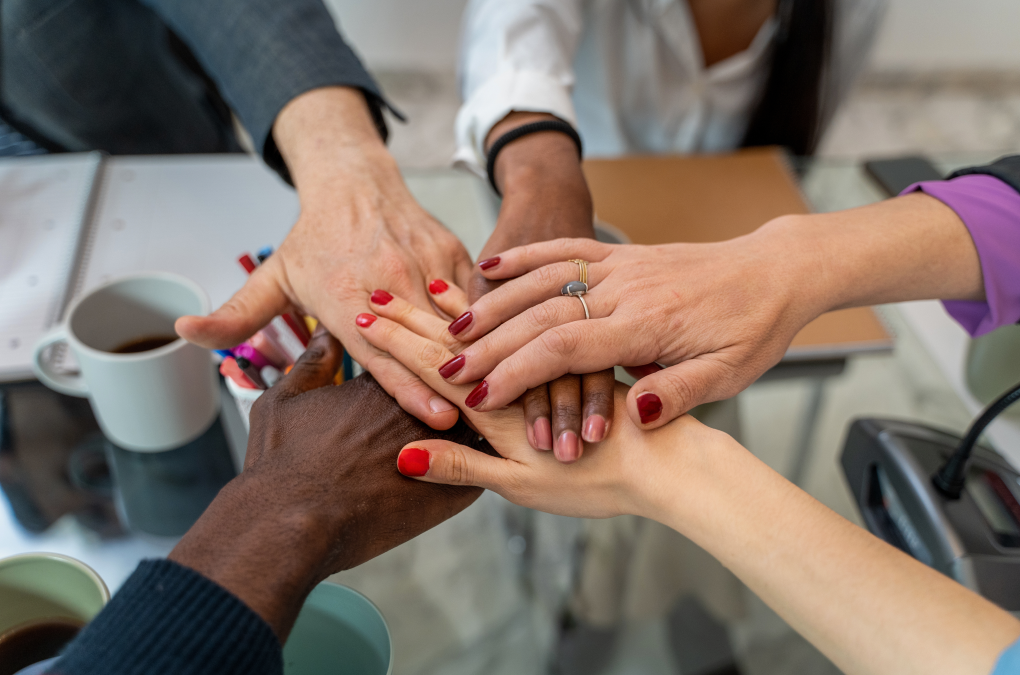 varias manos de personas diferentes unidas formando equipo