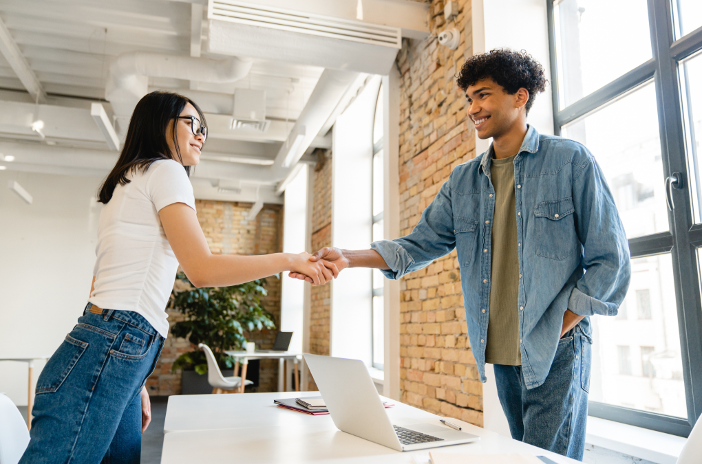 Dos personas jóvenes dándose la mano