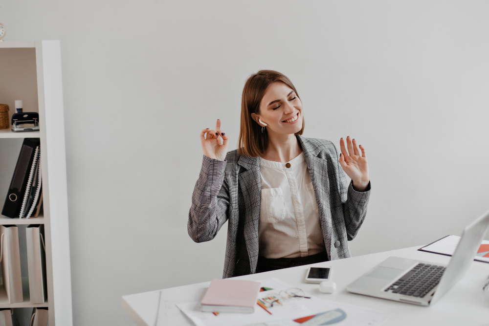Mujer sentada en una oficina feliz por su Flexibilidad Laboral